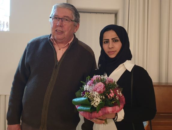 Georg Schrenk überreicht Khadija Alkhatib nach dem 32. Rundgespräch einen Blumenstrauß [author: Heide Terporten]
